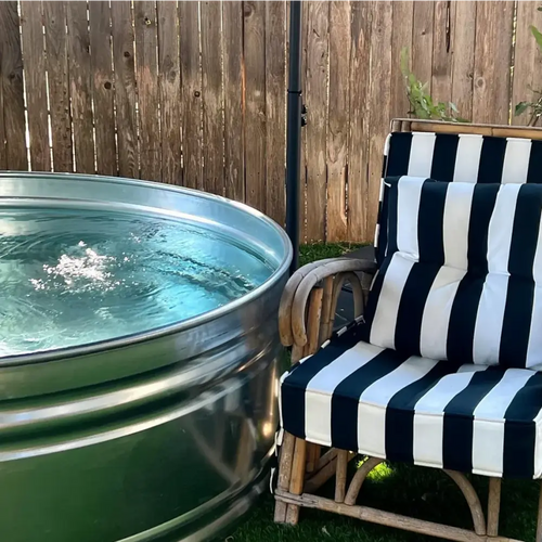 A large galvanized steel Stock tank pool DIY kit with sand filtration pump and valves set in a perth backyard 
